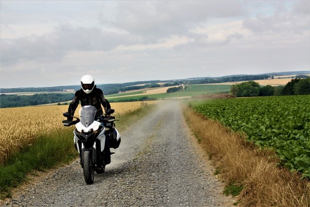 Vallonia in moto: fra orzo e patate. Può sembrare una foto inutile, in realtà questo scatto è fortemente simbolico della nostra esperienza vallona. proviamo la Multistrada 950 su una strada bianca fra un campo di orzo (dal quale si ricava la birra) e uno di patate, altro simbolo della gastronomia belga. In realtà il nostro inviato ha rischiato di arrivare lungo sulla strada asfaltata che incrociava.